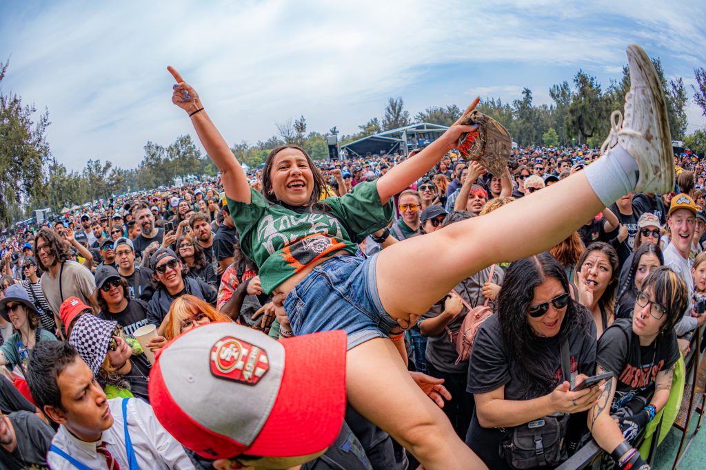 Asistente haciendo crowdsurfing entre el público durante el festival Vans Warped Tour México 2026.