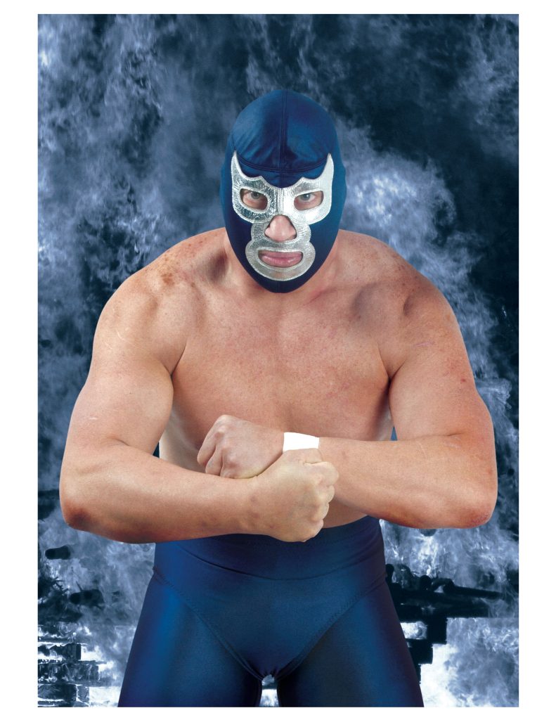 Fotografía de estudio del luchador Blue Demon Jr. posando con los brazos cruzados y su clásica máscara azul.